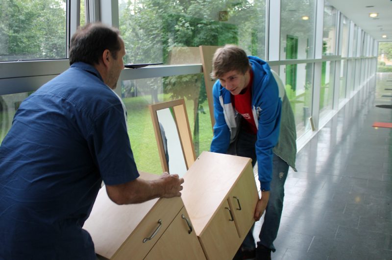 Simon und Hermann Költringer beim Einräumen eines Studenten-Appartements nach der Renovierung.