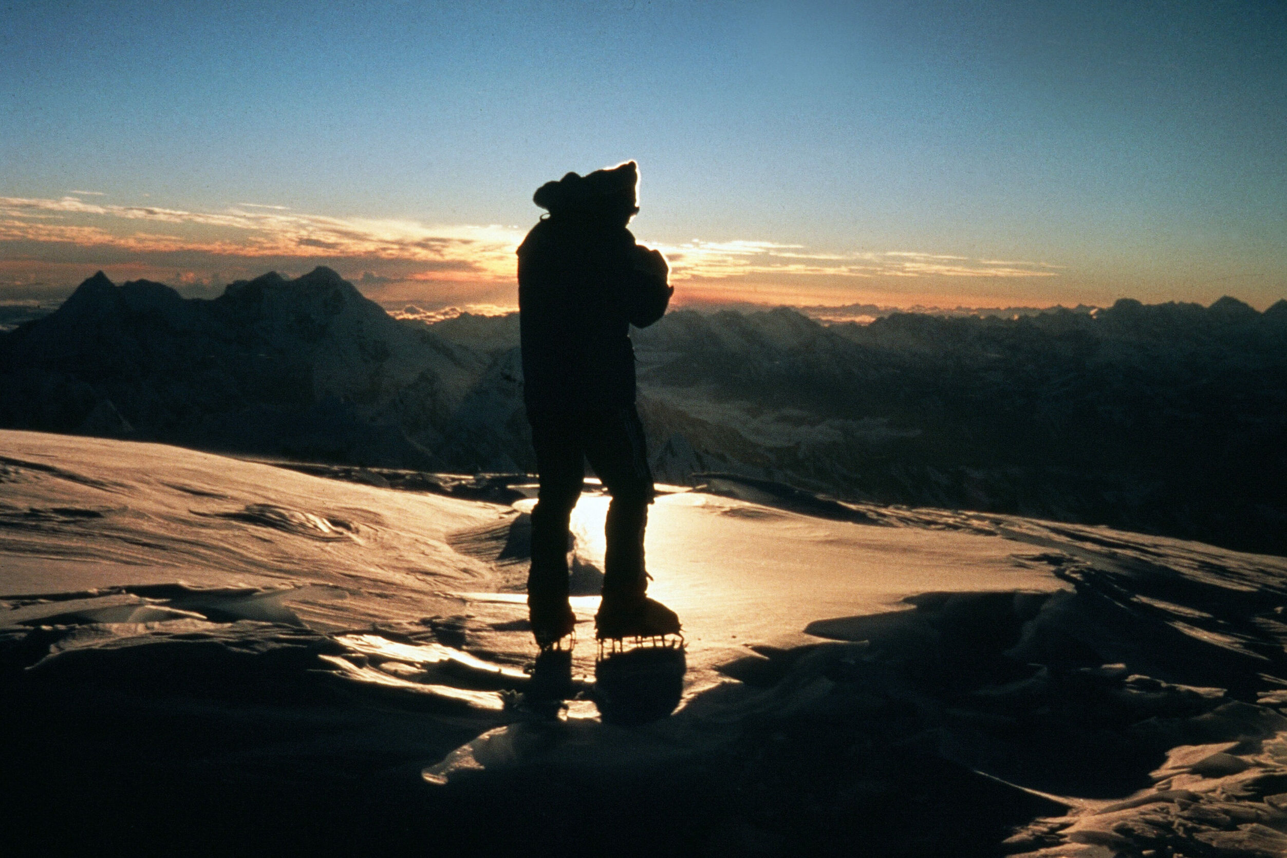 Bergsteiger im Gegenlicht des Sonnenuntergangs am eisbedeckten Gipfel des Cho Oyu.