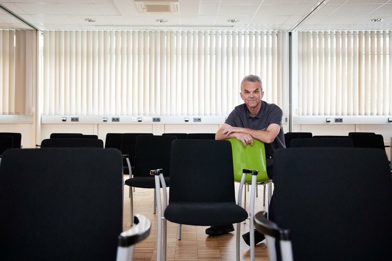 Hannes Niederreiter sitzt mit den Armen auf einem Sessel verschränkt inmitten von Stühlen im Techno-Z Veranstaltungszentrum.